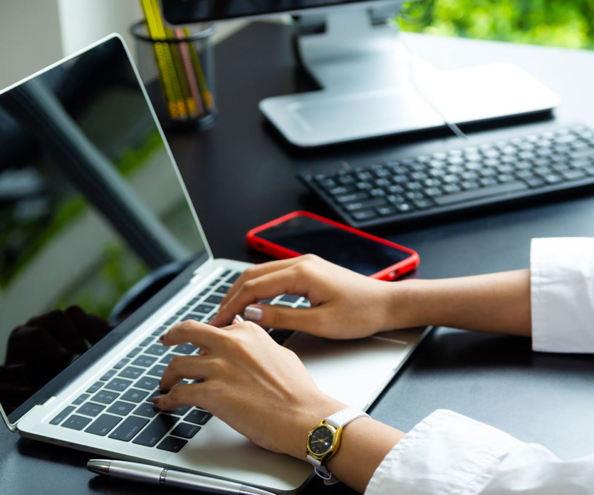 Close up of a woman typing on a laptop